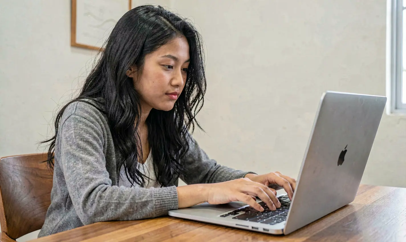 RKGG Games – Enjoy smooth and engaging online casino gameplay anytime in Indonesia Focused Indonesian female gamer playing online casino games on a laptop with the RKGG platform in a modern digital gaming environment